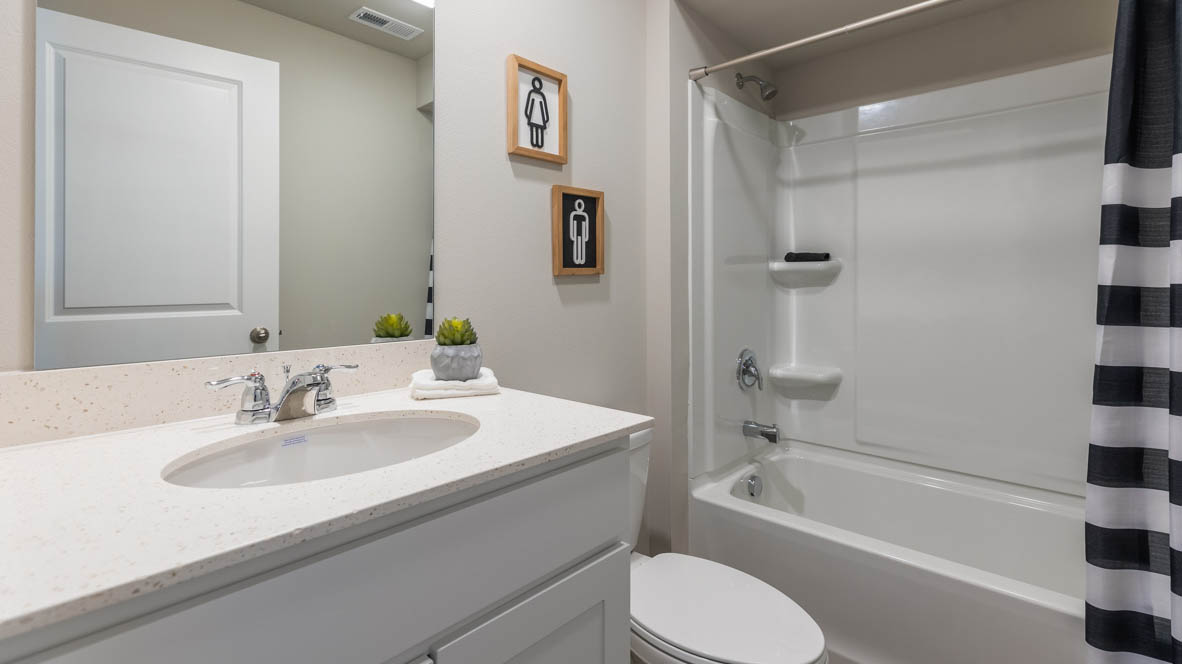 Bathroom with tub and shower combo, quartz countertops, and white vanity