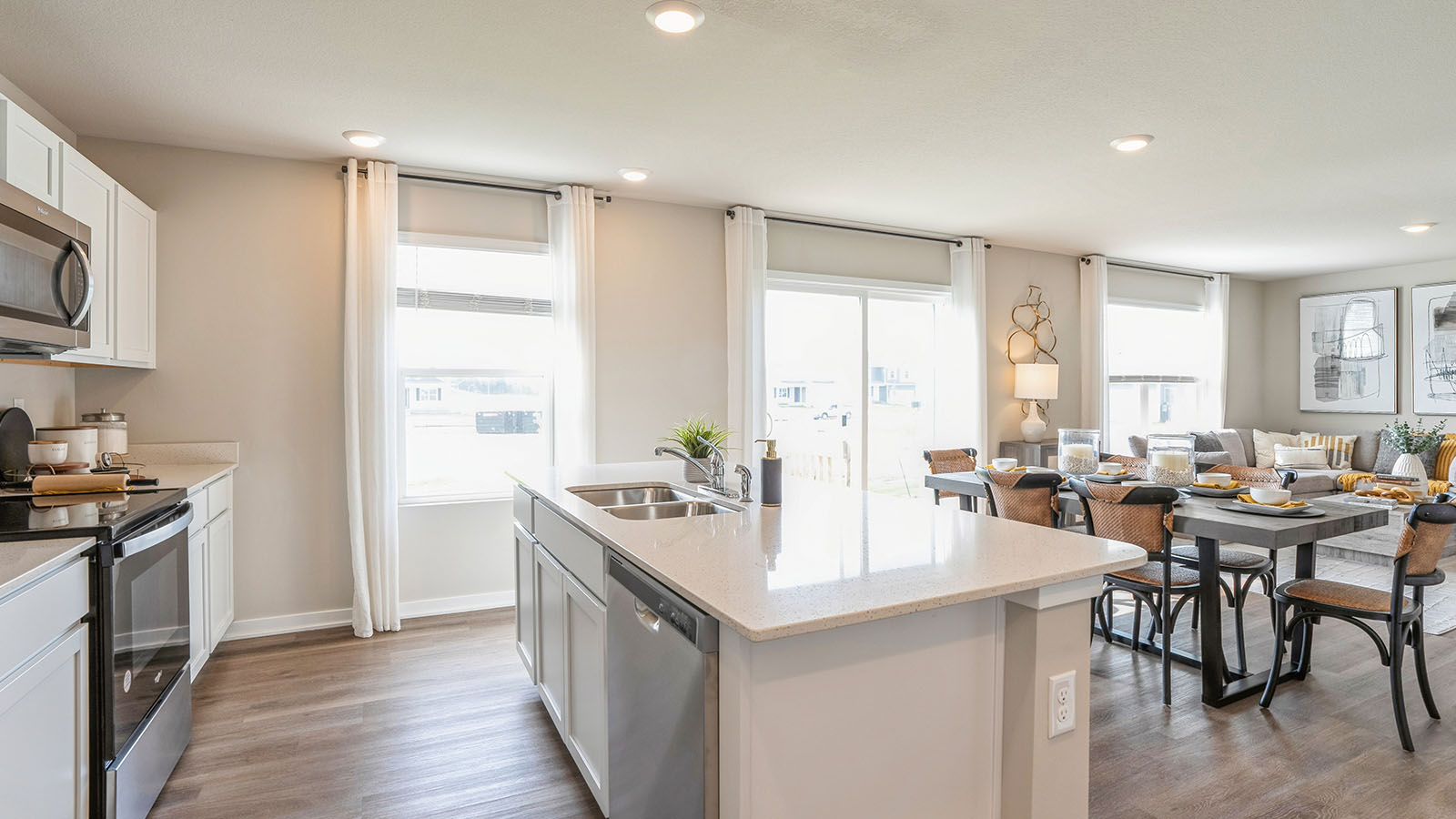 Kitchen with stainless steel appliances, quartz countertops, and white cabinetry