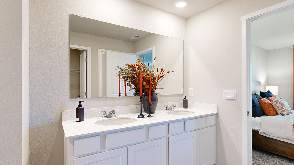 Spacious bathroom with white cabinetry and double sinks