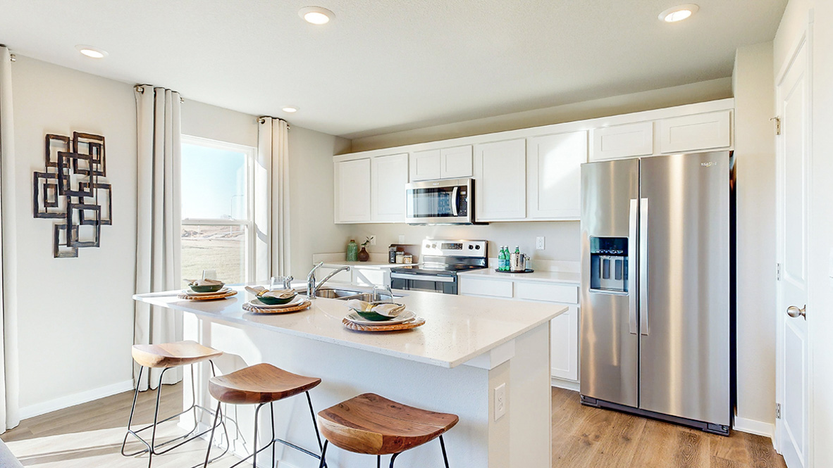 Kitchen with stainless steel appliances, quartz countertops, and white cabinetry