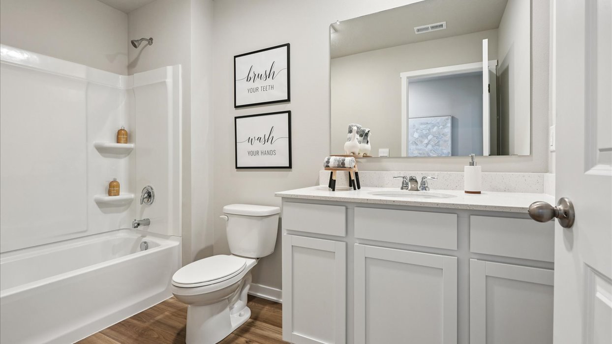 Bathroom with tub and shower combo, quartz countertops, and white vanity