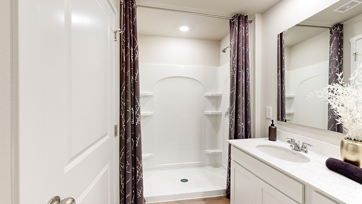 Spacious primary bathroom featuring dual vanities, modern fixtures, and a walk-in shower.