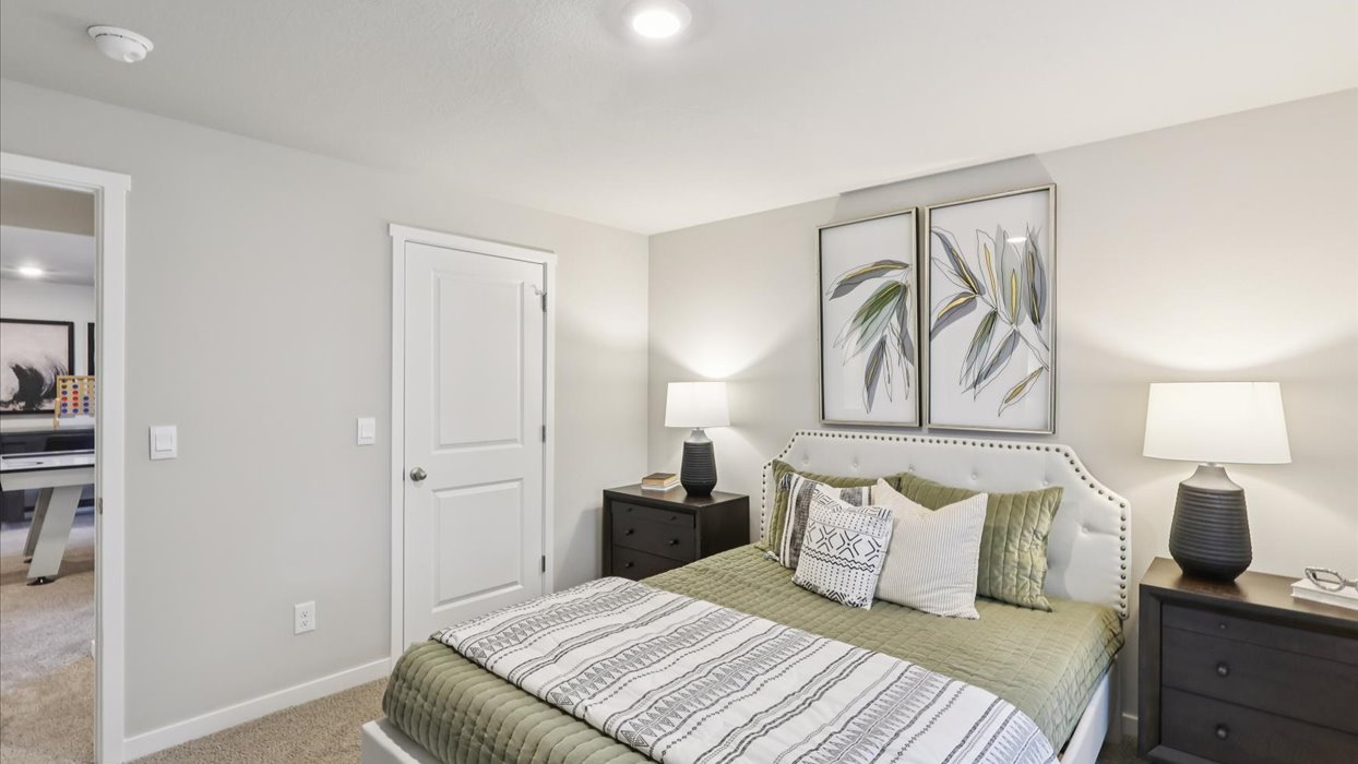 Private lower-level bedroom with natural light and functional storage space.