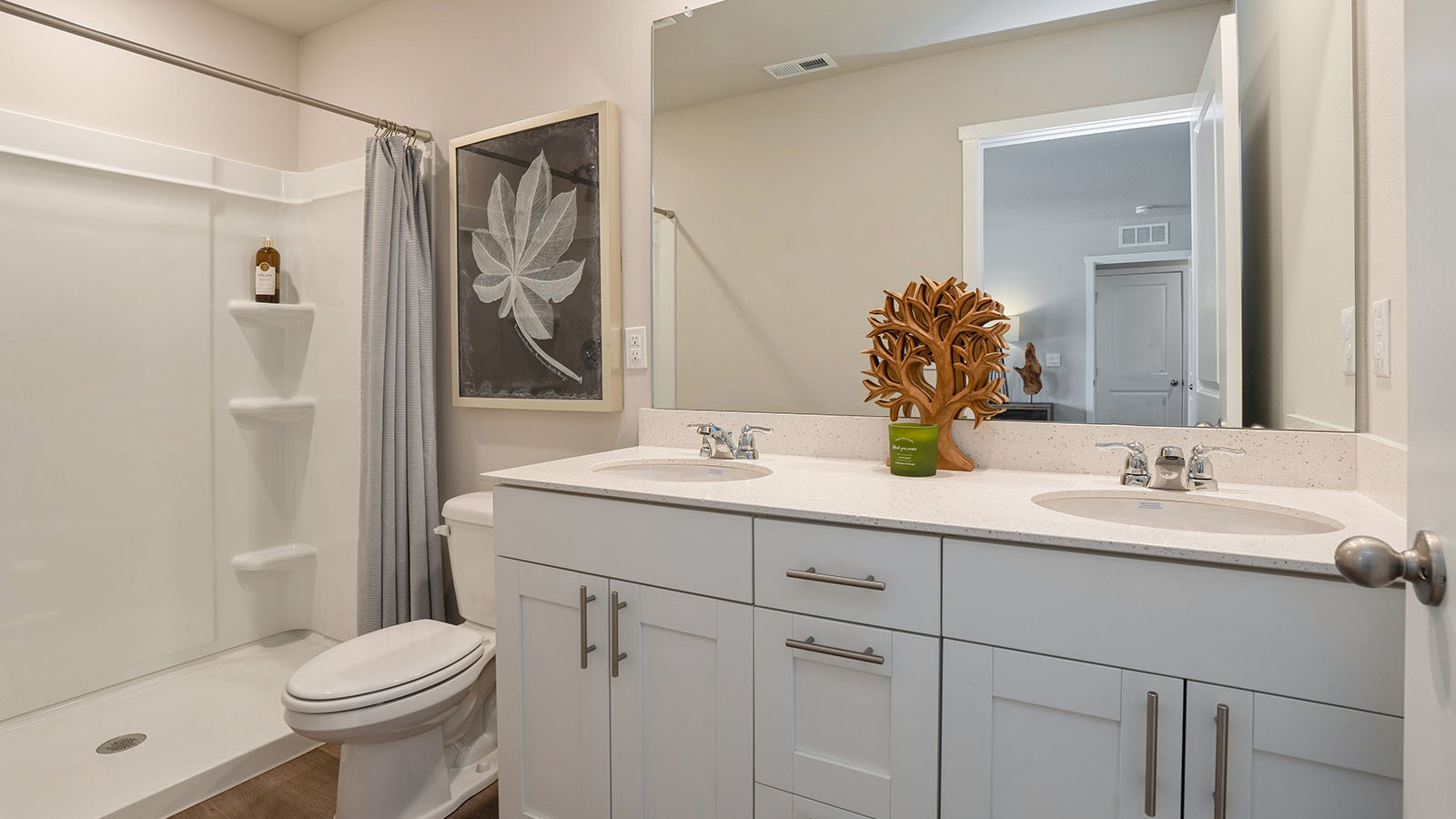 Spacious primary bathroom featuring dual vanities, modern fixtures, and a walk-in shower.
