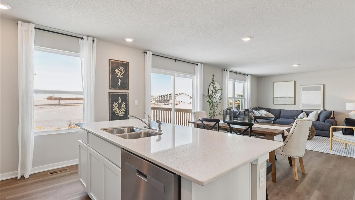 Kitchen with stainless steel appliances, quartz countertops, and white cabinetry