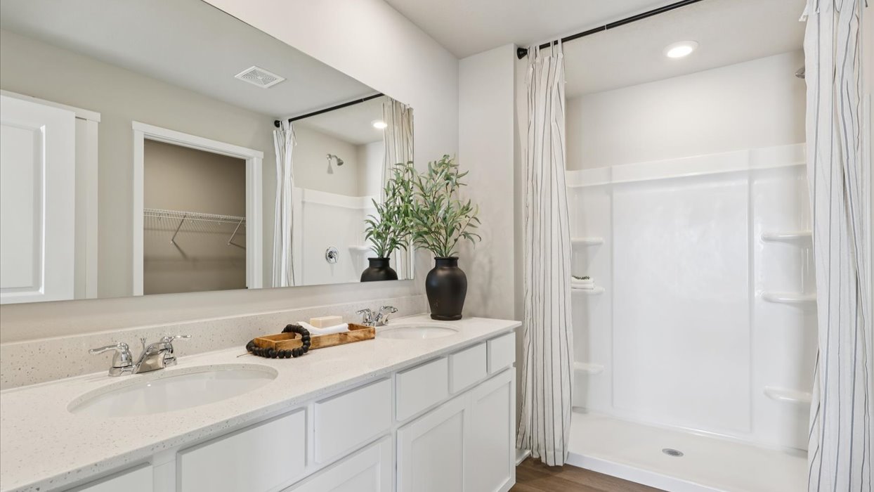 Spacious bathroom with white cabinetry and double sinks