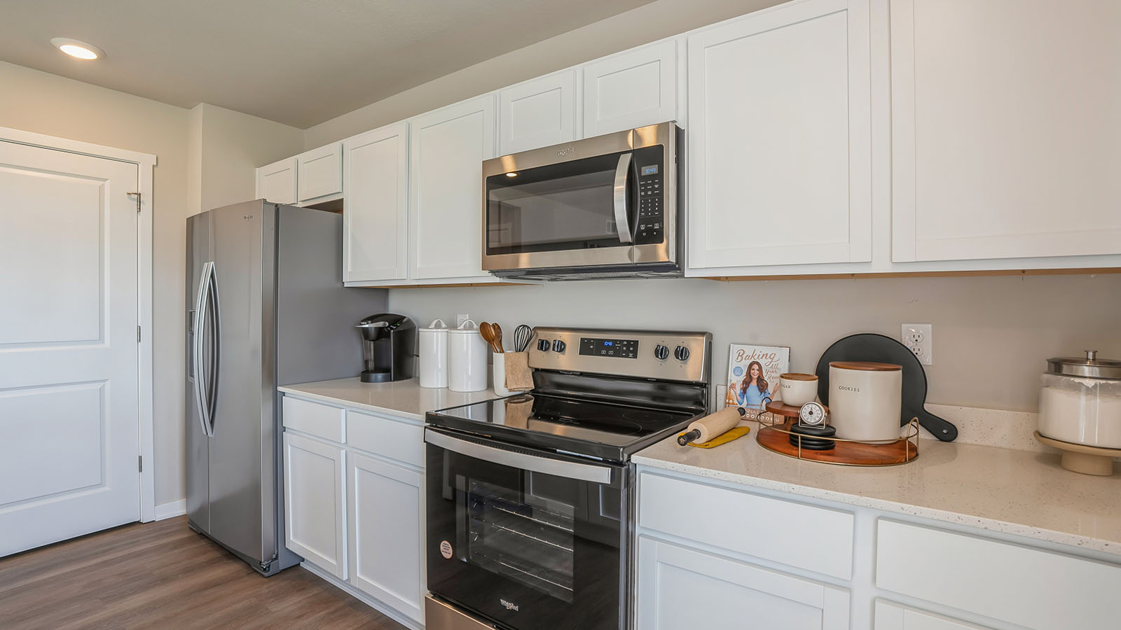 Kitchen with stainless steel appliances, quartz countertops, and white cabinetry