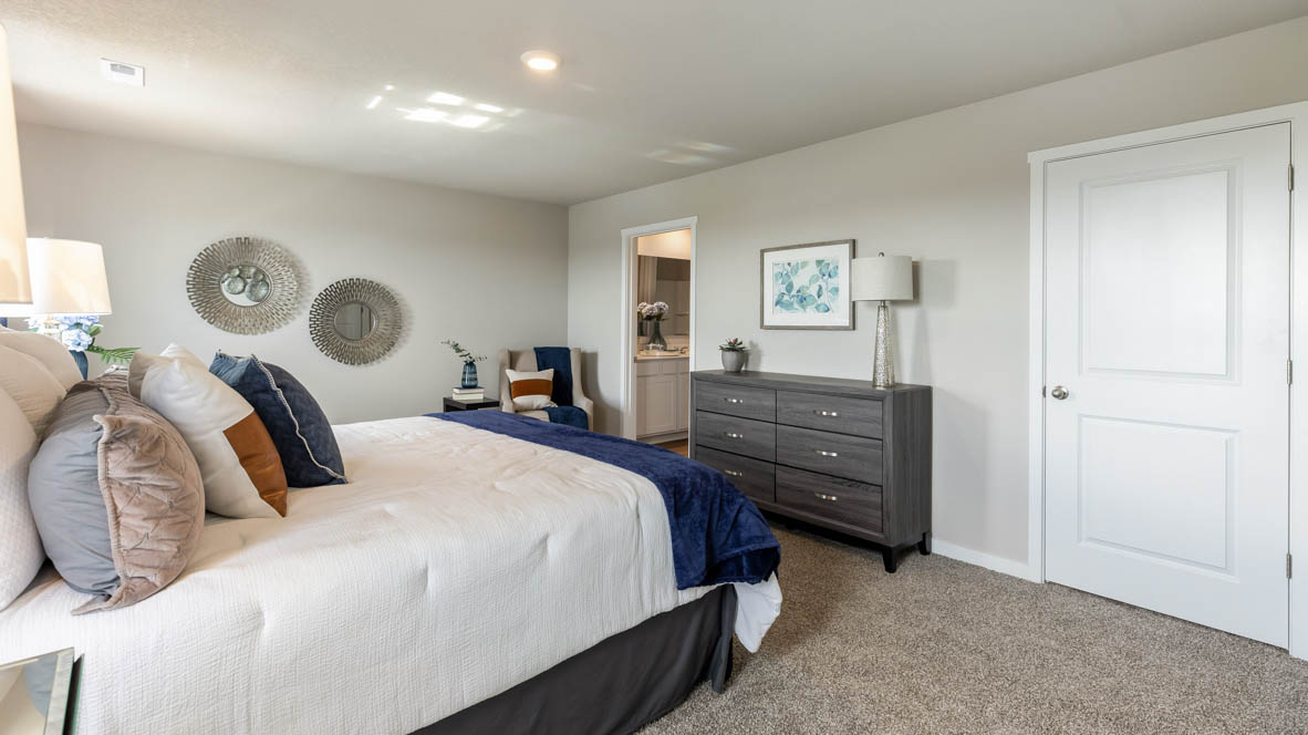 Spacious primary suite with natural light, attached bathroom, & walk in closet