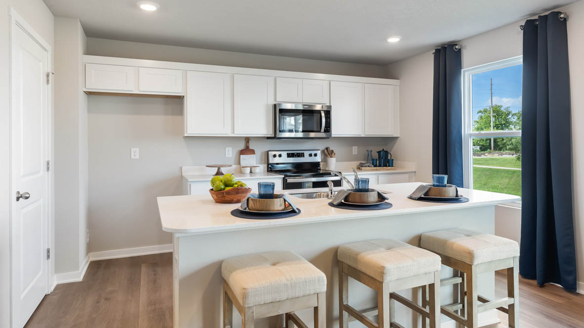 Kitchen with stainless steel appliances, quartz countertops, and white cabinetry