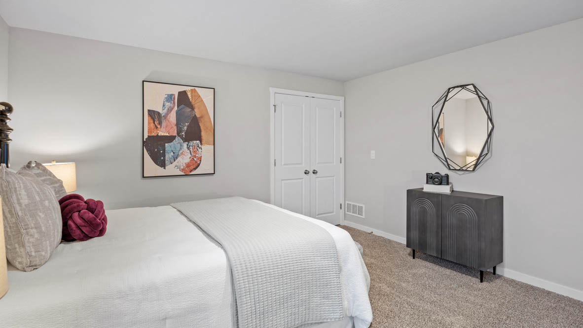 Private lower-level bedroom with natural light and functional storage space.