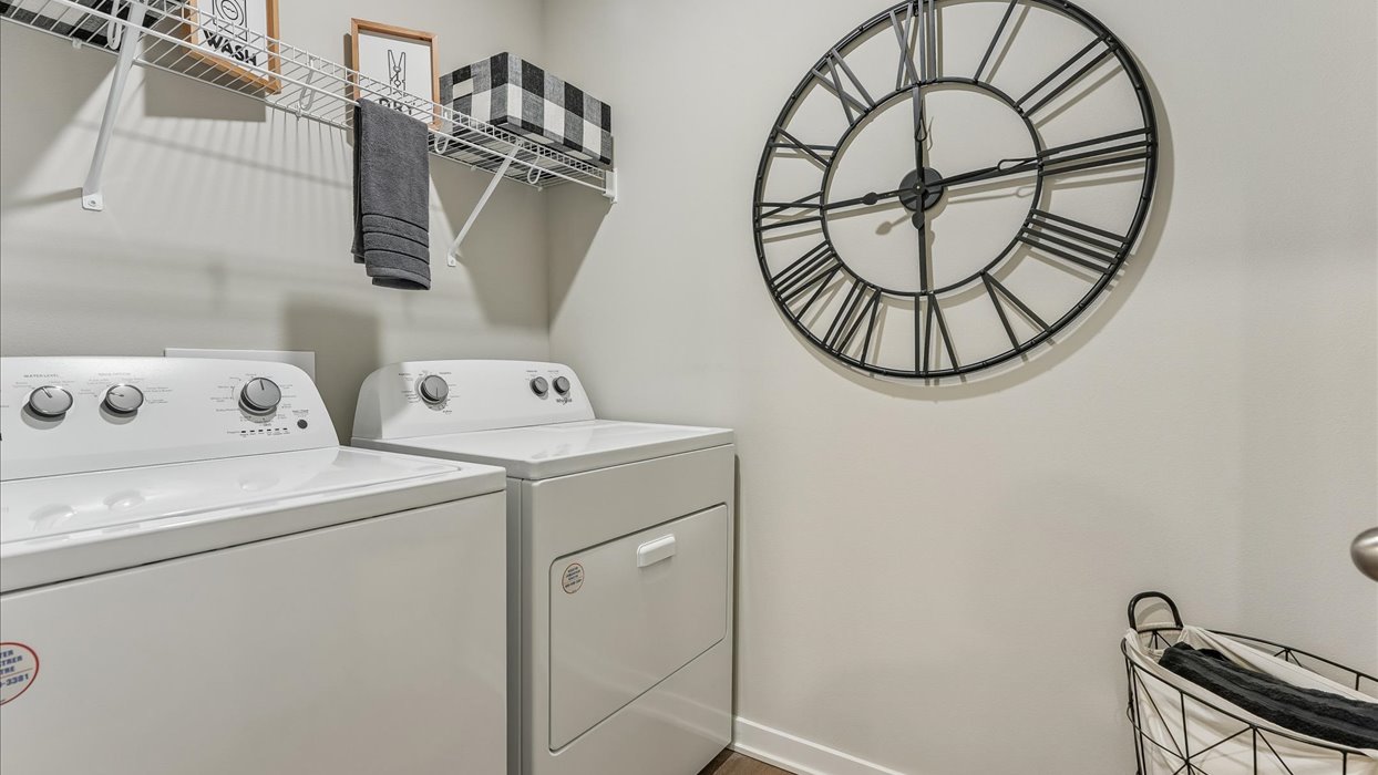 Dedicated laundry room with built-in shelving and utility connections.