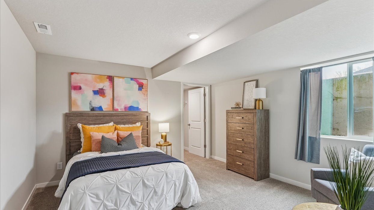 Private lower-level bedroom with natural light and functional storage space.