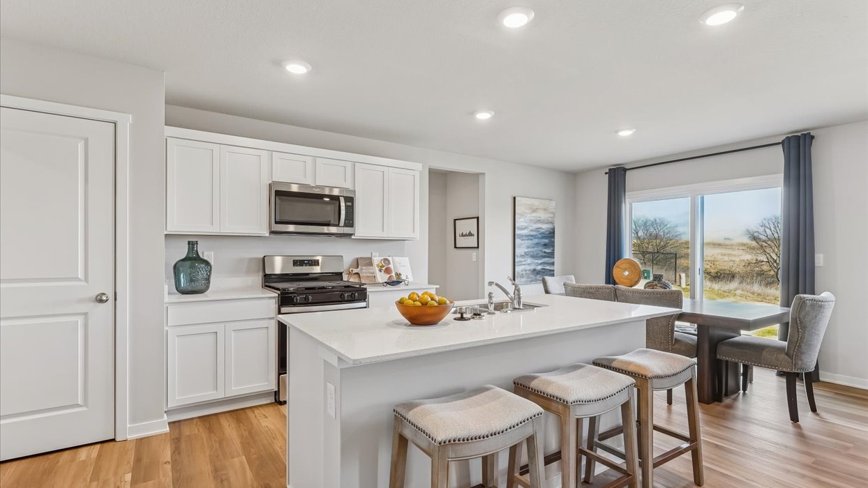 kitchen with white cabinets next to dining area
