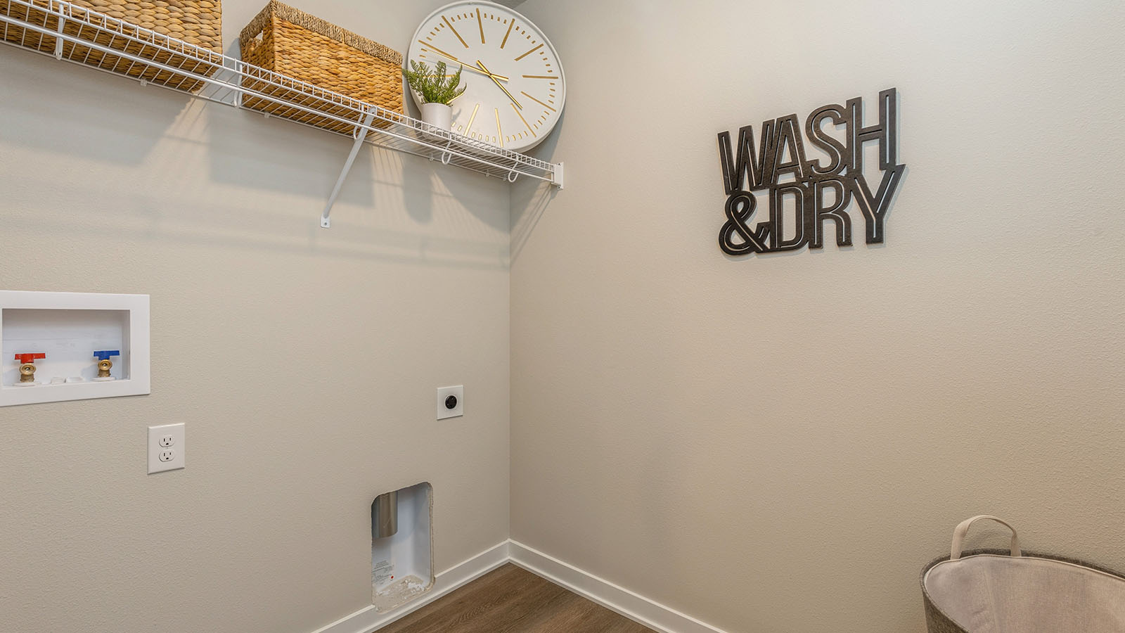 Dedicated laundry room with built-in shelving and utility connections.