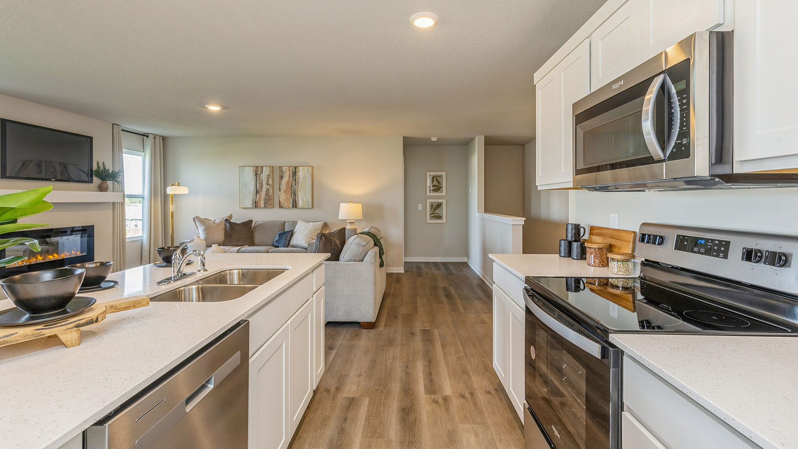 Kitchen with stainless steel appliances, quartz countertops, and white cabinetry