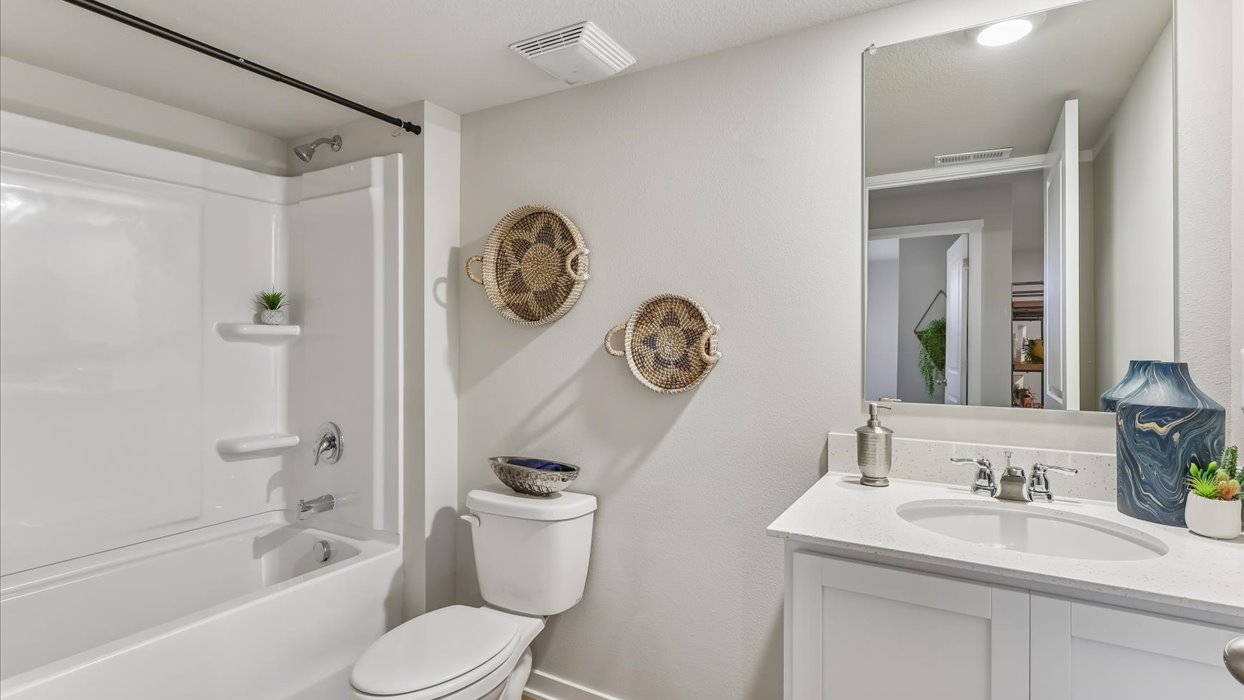 Bathroom with tub and shower combo, quartz countertops, and white vanity