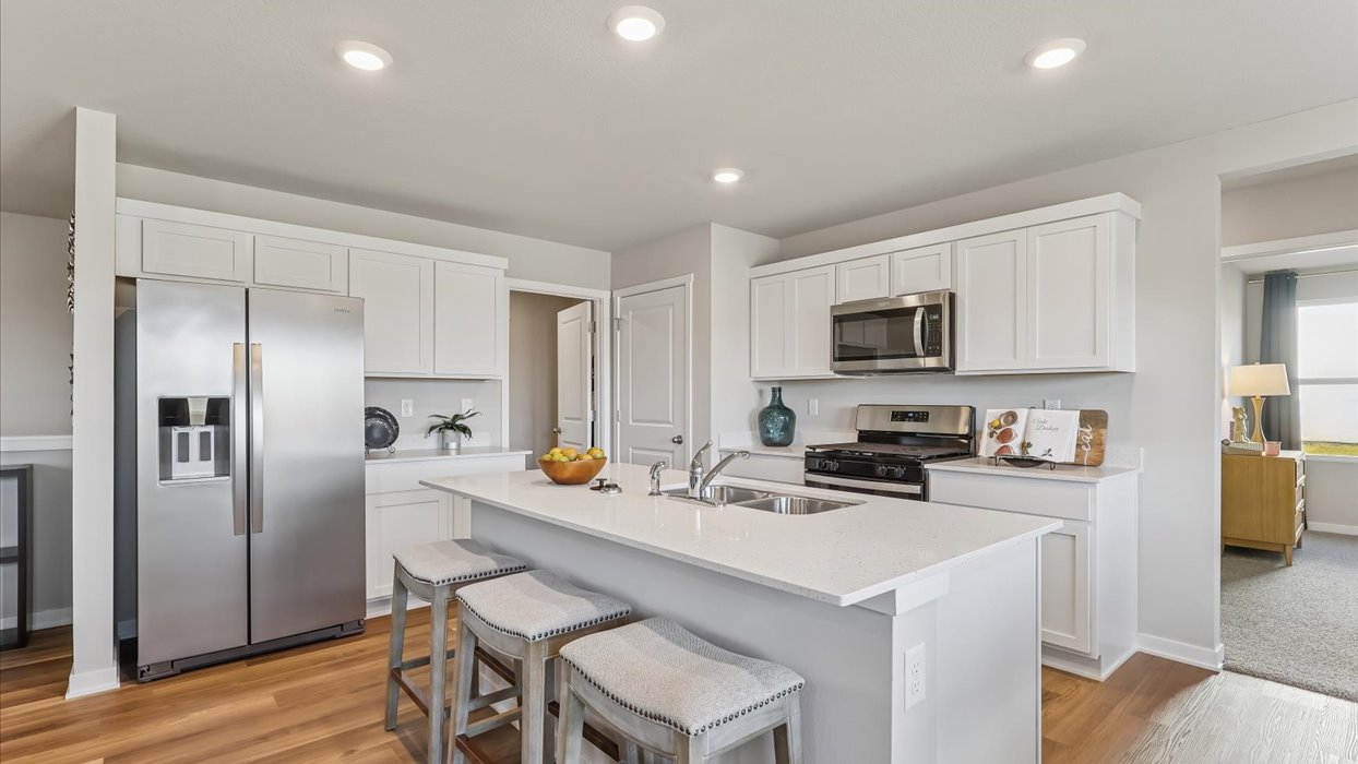 Kitchen with stainless steel appliances, quartz countertops, and white cabinetry