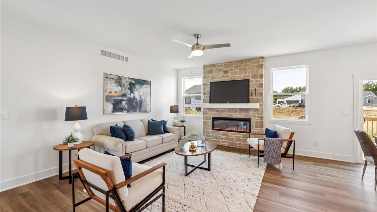 spacious living room with ceiling fan and stone electric fireplace