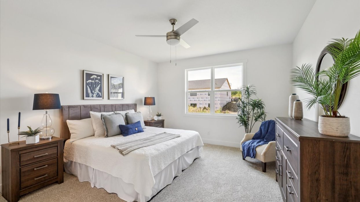 primary bedroom with large window and overhead lighting