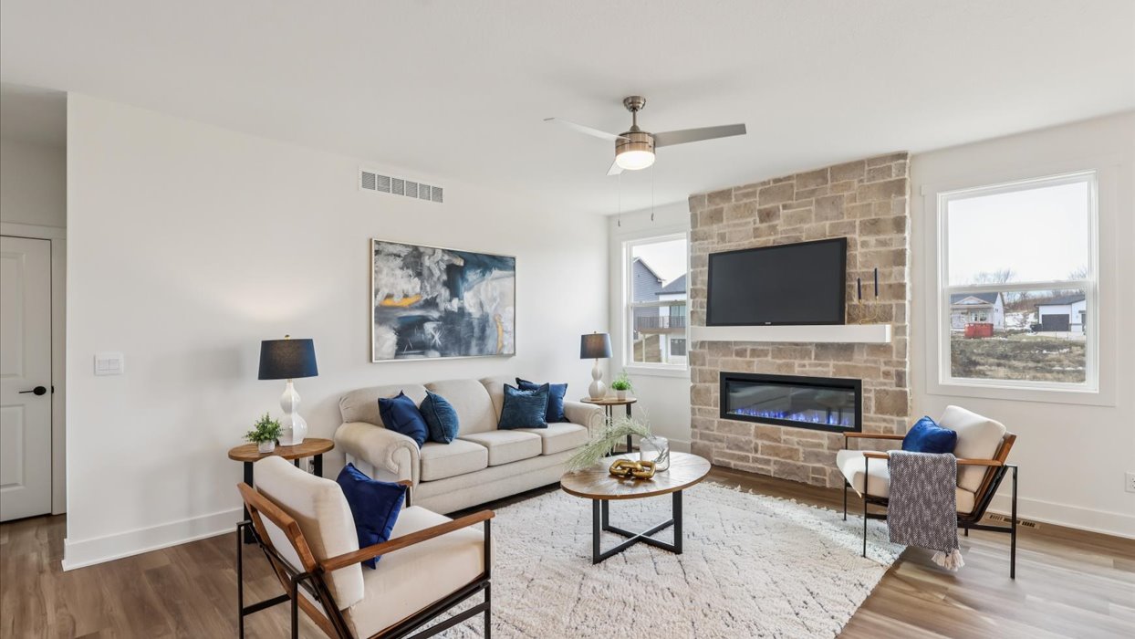 Main level living room offers refined style with electric fireplace, open concept connections to kitchen and living spaces