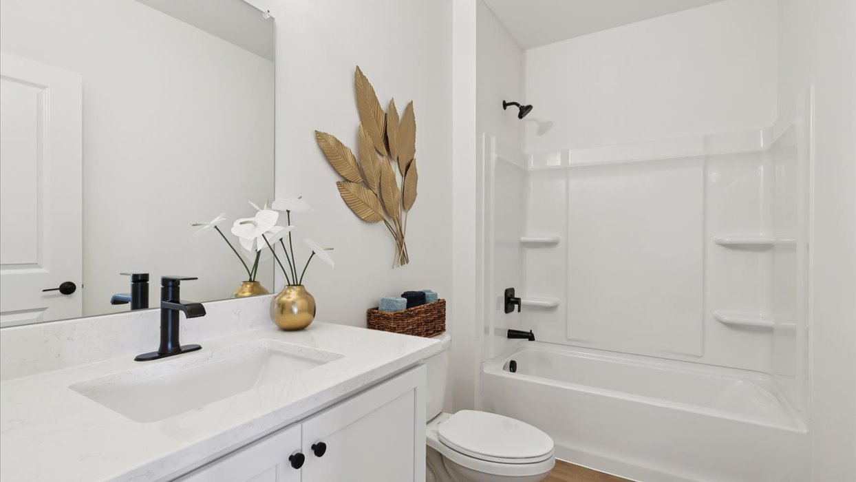 Bathroom with tub and shower combo, quartz countertops, and white vanity