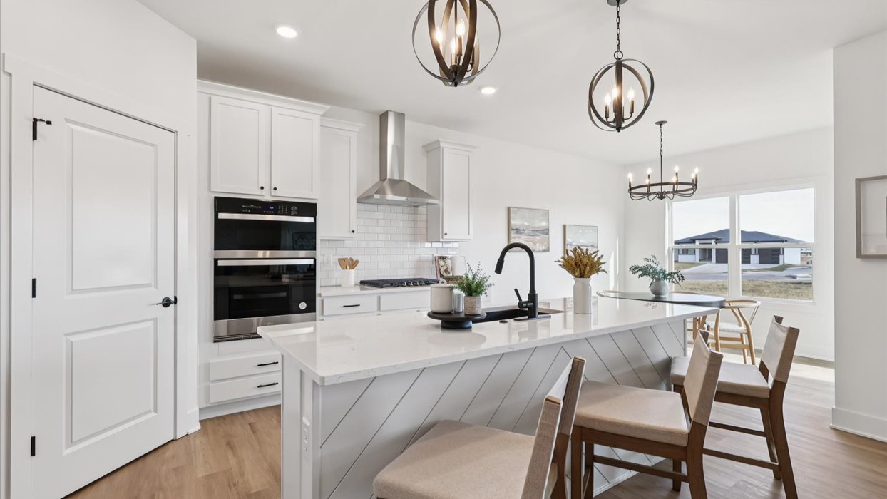 Kitchen with stainless steel appliances, quartz countertops, and white cabinetry
