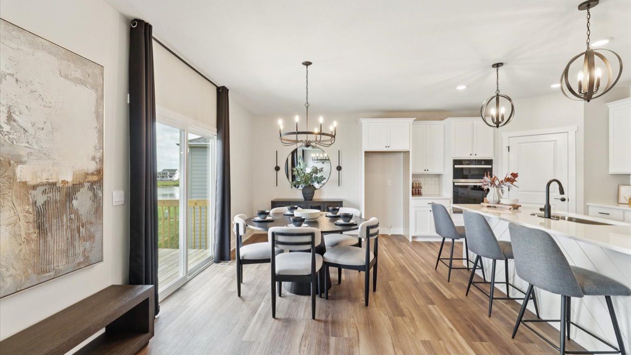 Living room looking toward dining, kitchen and outdoor areas with natural light and smooth open-concept flow
