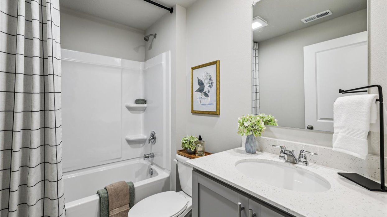 bathroom with large mirror and bathtub