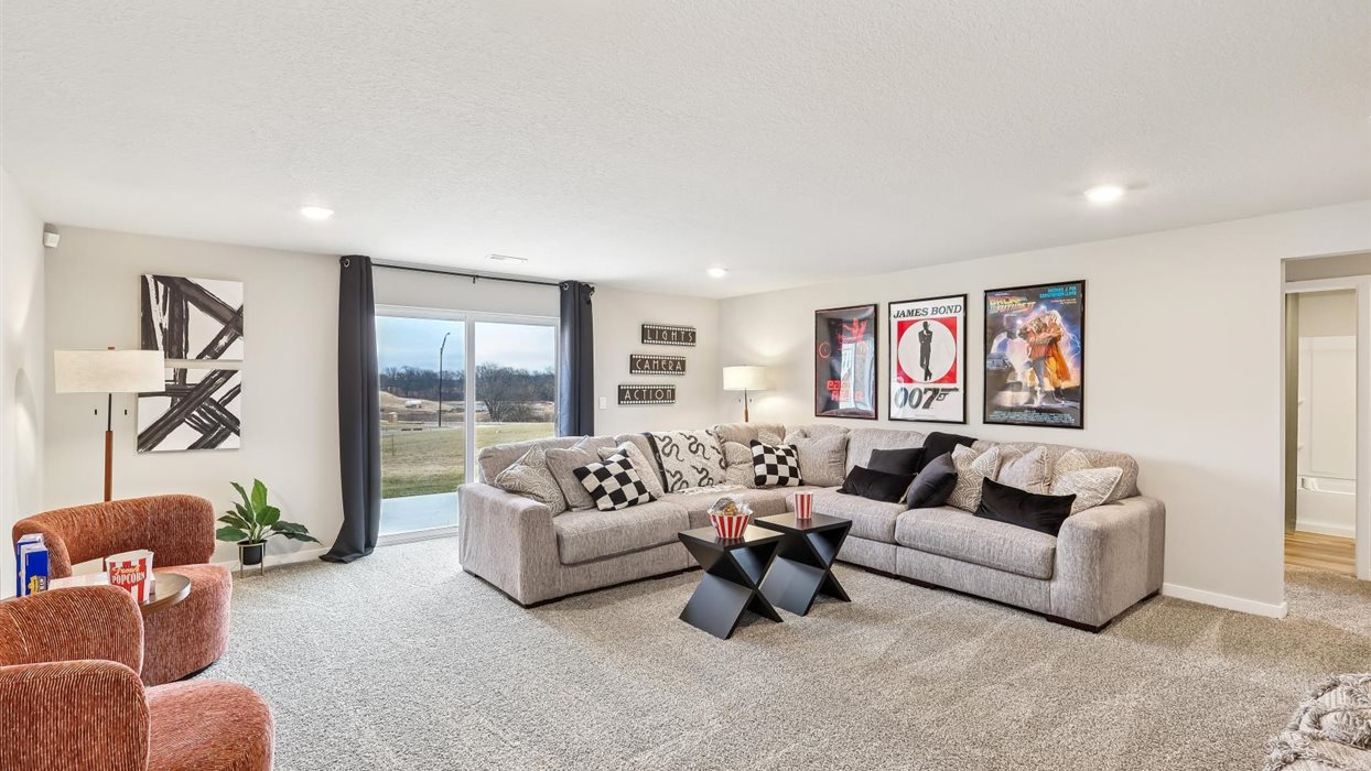 finished basement with grey couch and sliding glass doors