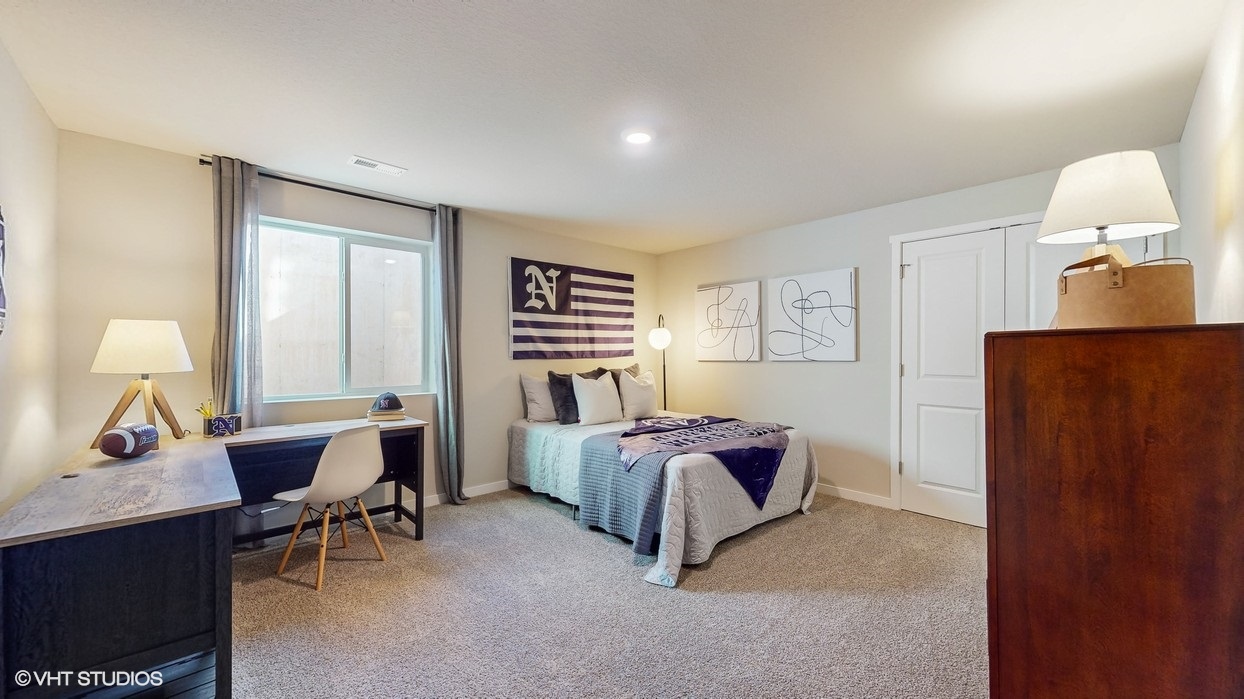 Private lower-level bedroom with natural light and functional storage space.