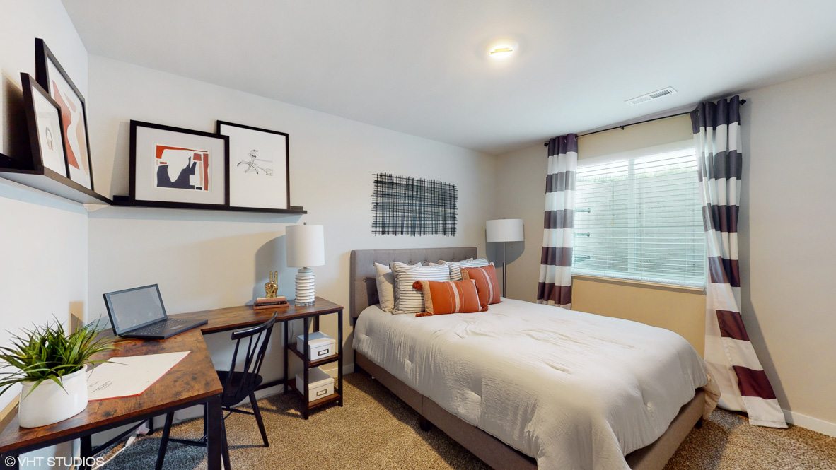 Private lower-level bedroom with natural light and functional storage space.