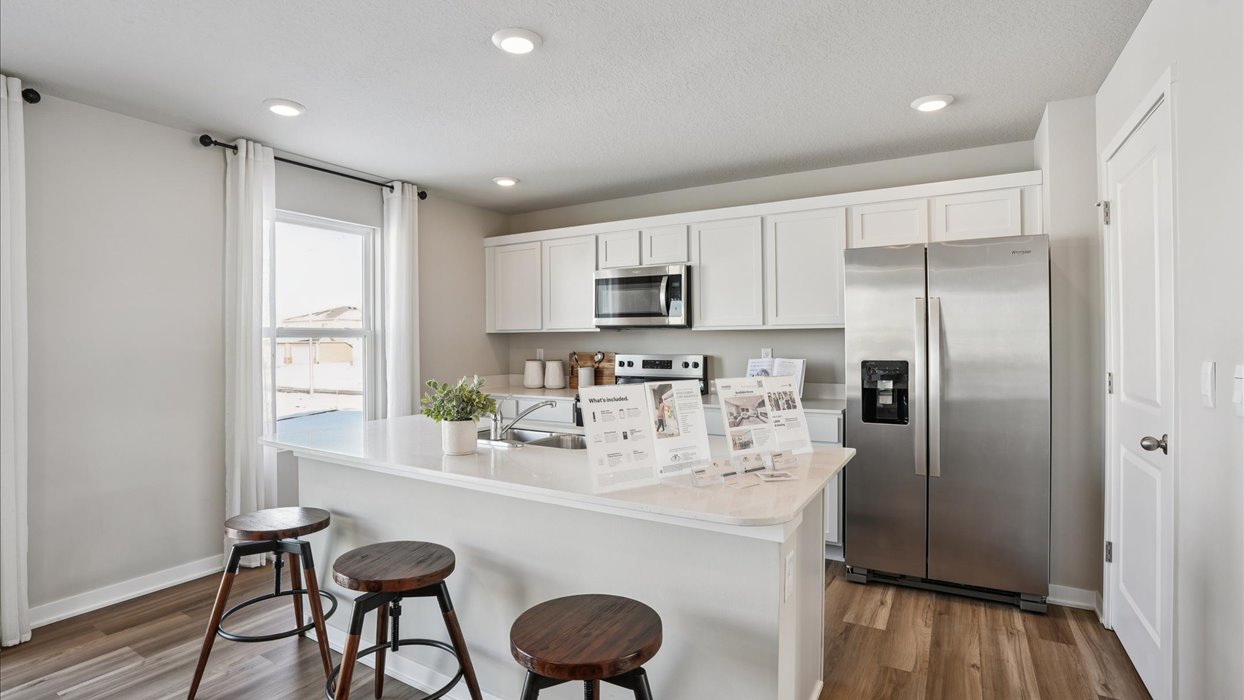 Kitchen with stainless steel appliances, quartz countertops, and white cabinetry