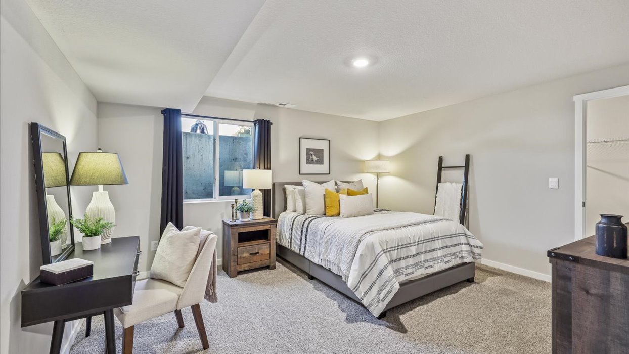 Private lower-level bedroom with natural light and functional storage space.
