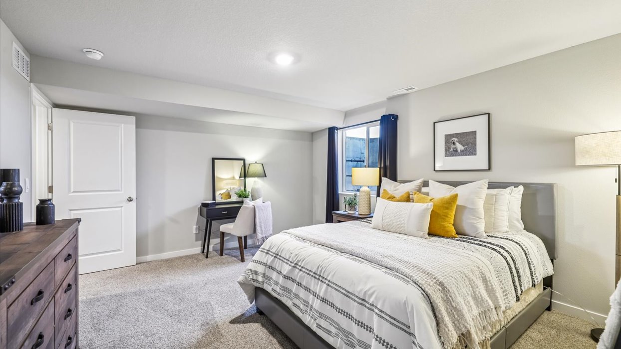 Private lower-level bedroom with natural light and functional storage space.