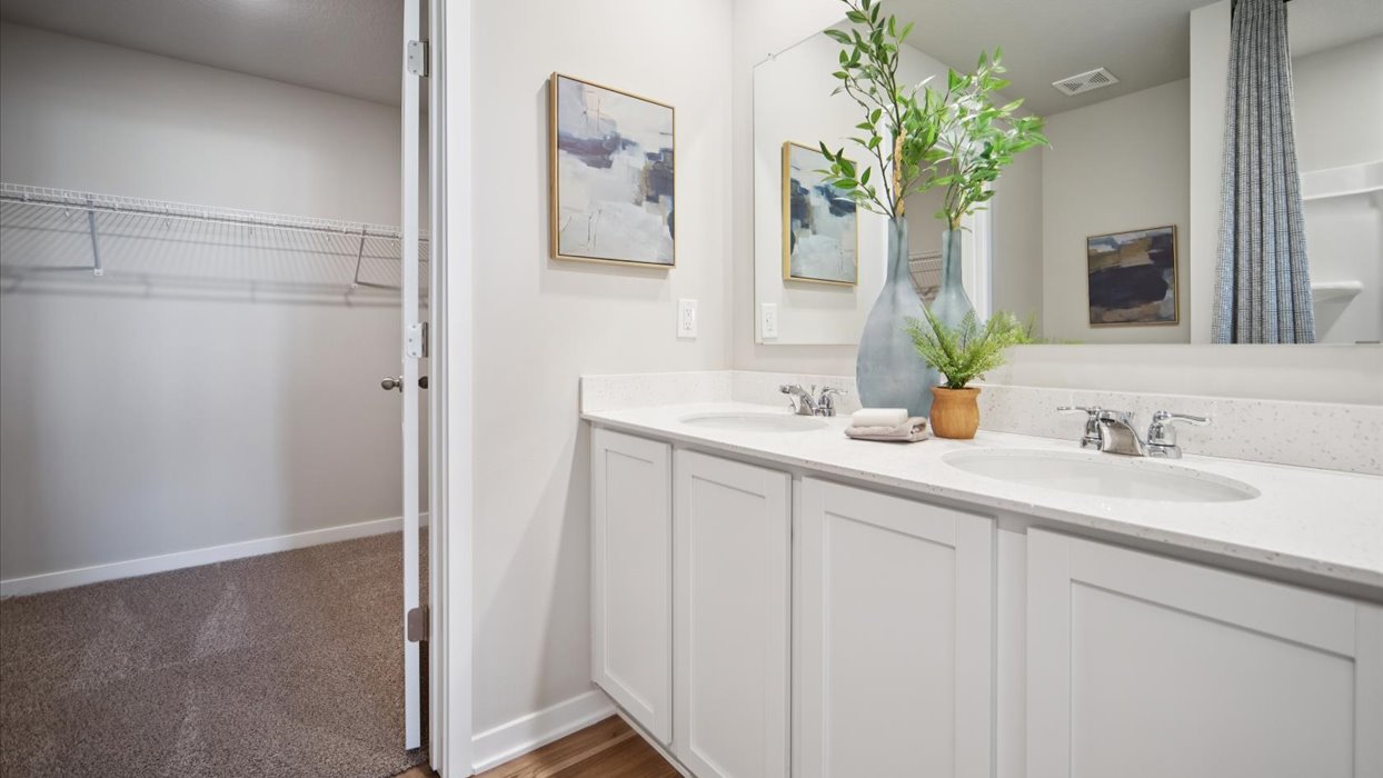 Spacious primary bathroom featuring dual vanities, modern fixtures, and a walk-in shower.