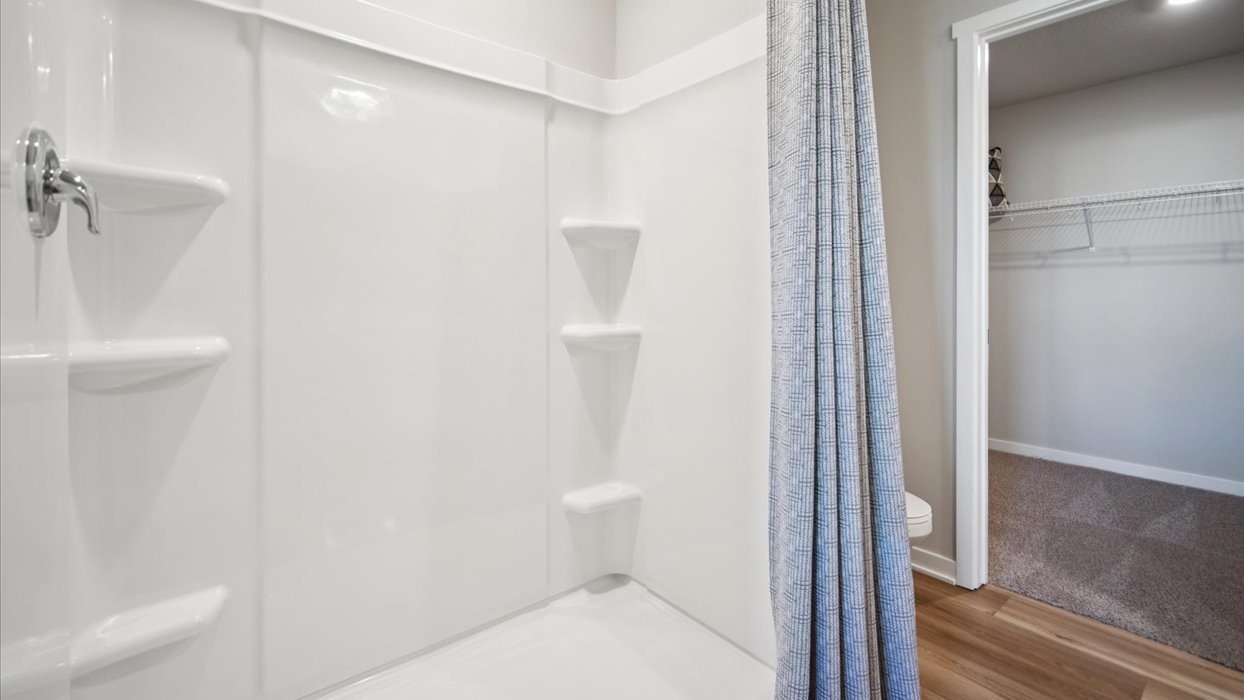 Spacious primary bathroom featuring dual vanities, modern fixtures, and a walk-in shower.