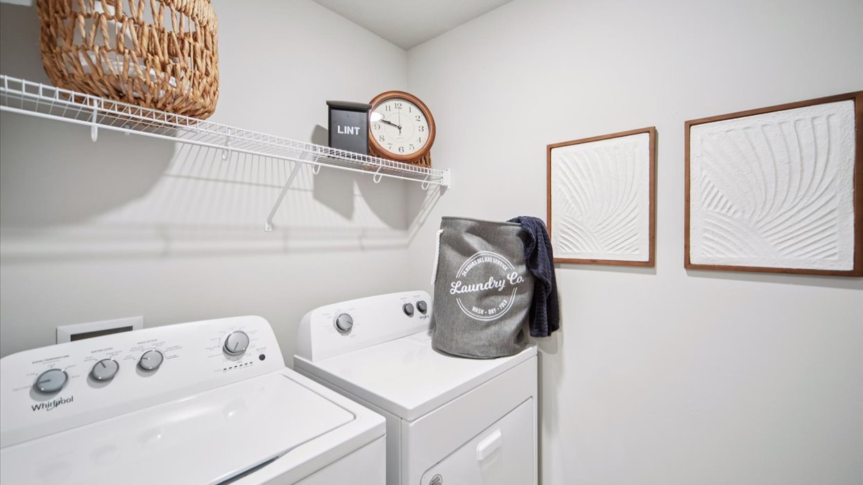 Dedicated laundry room with built-in shelving and utility connections.