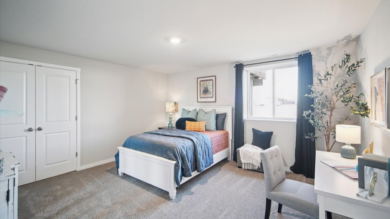 Private lower-level bedroom with natural light and functional storage space.