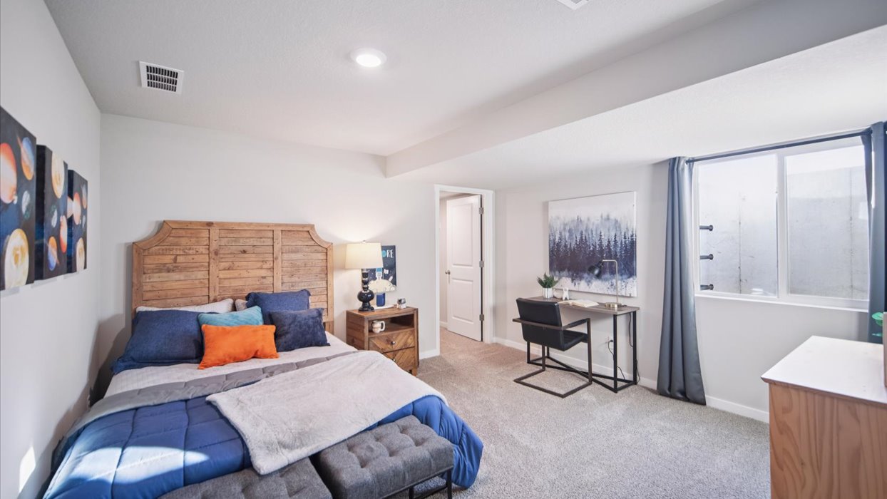 Private lower-level bedroom with natural light and functional storage space.