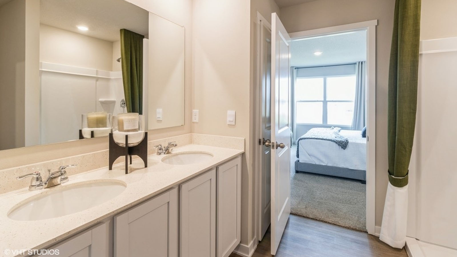 Spacious primary bathroom featuring dual vanities, modern fixtures, and a walk-in shower.