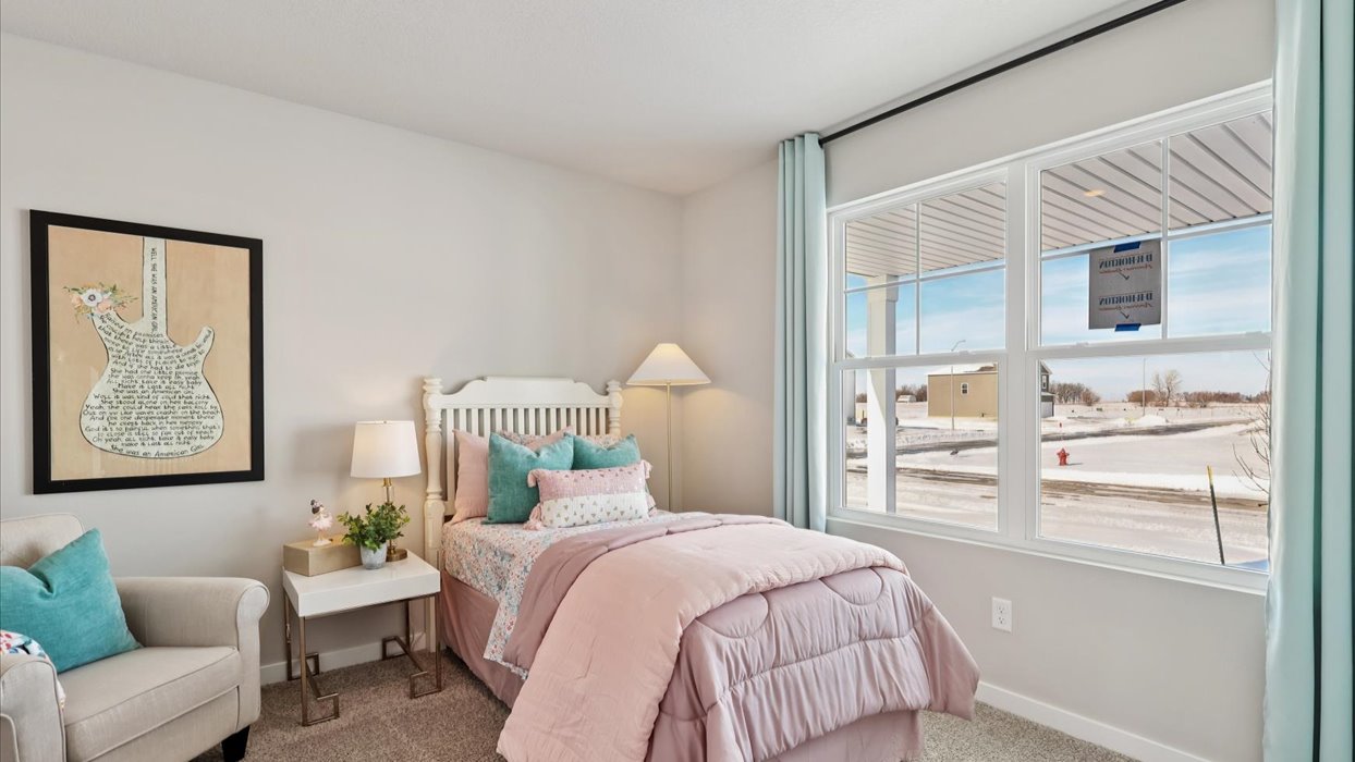 first bedroom with pink twin bed and small window