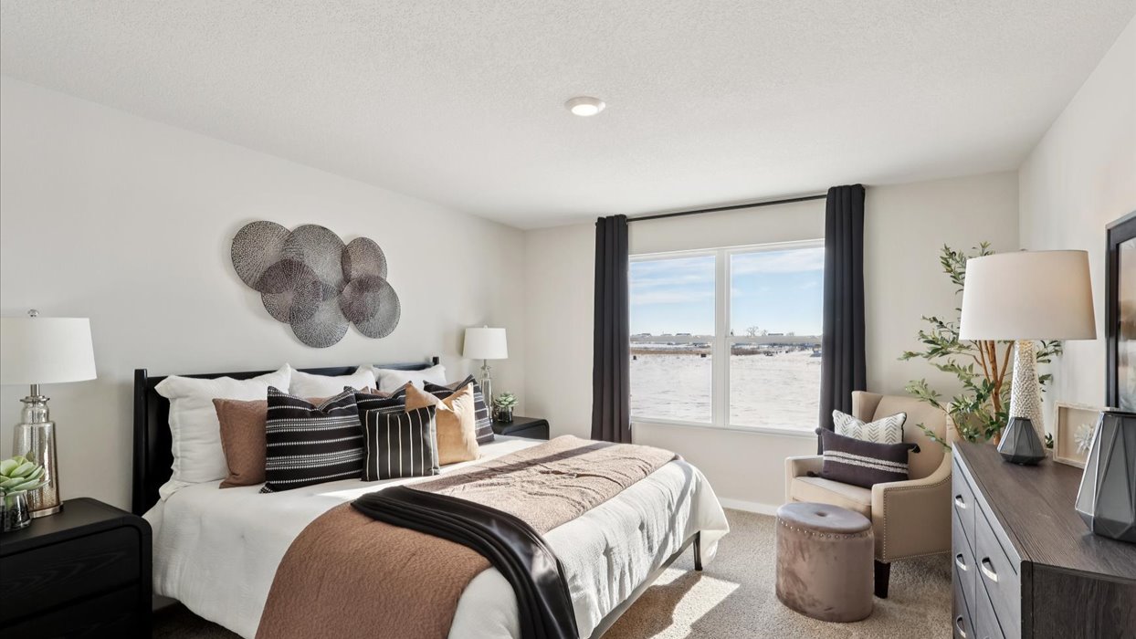 primary bedroom with large window and bed