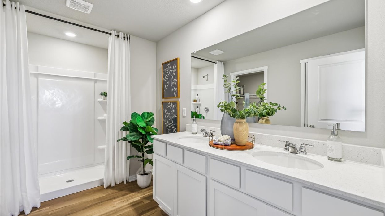 Spacious bathroom with white cabinetry and double sinks