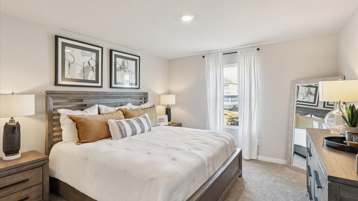 primary bedroom with large window and bed with nightstands