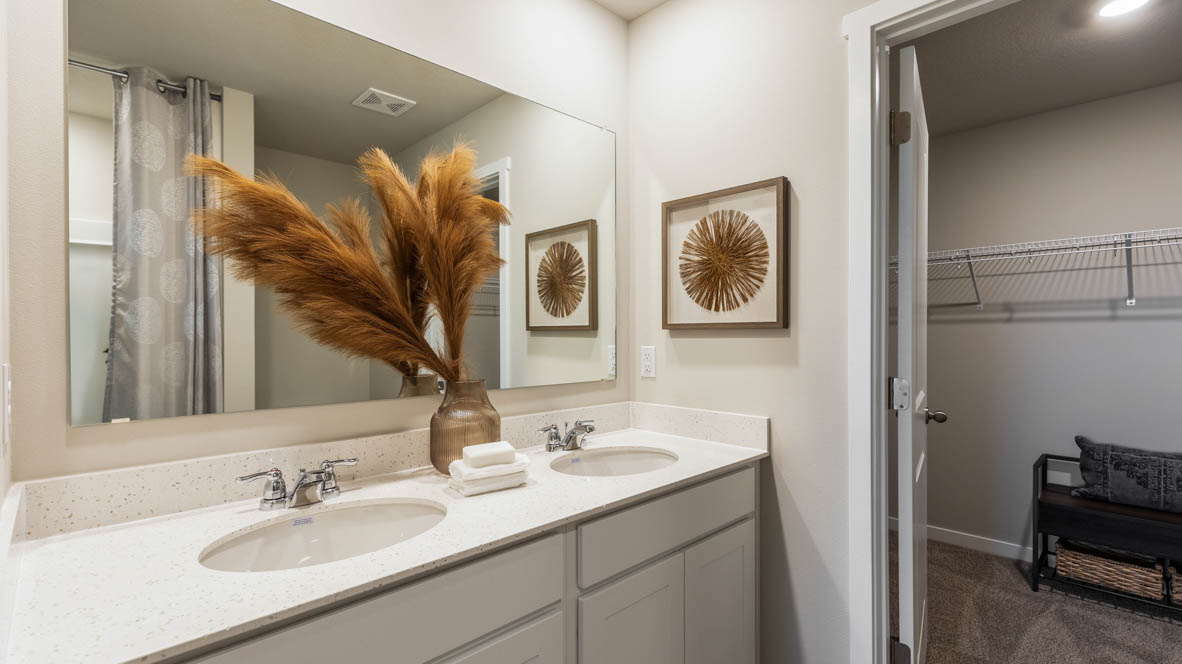 Spacious bathroom with white cabinetry and double sinks