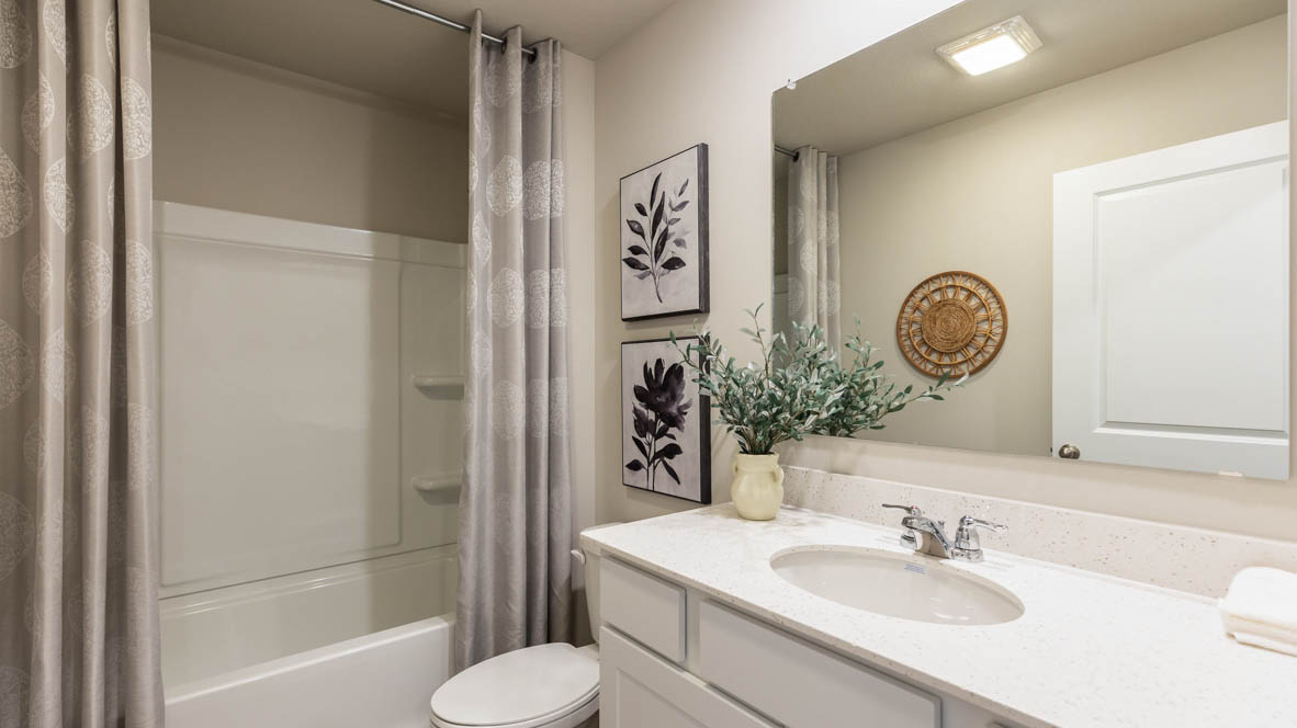 Bathroom with tub and shower combo, quartz countertops, and white vanity