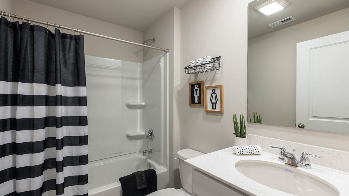 Bathroom with tub and shower combo, quartz countertops, and white vanity
