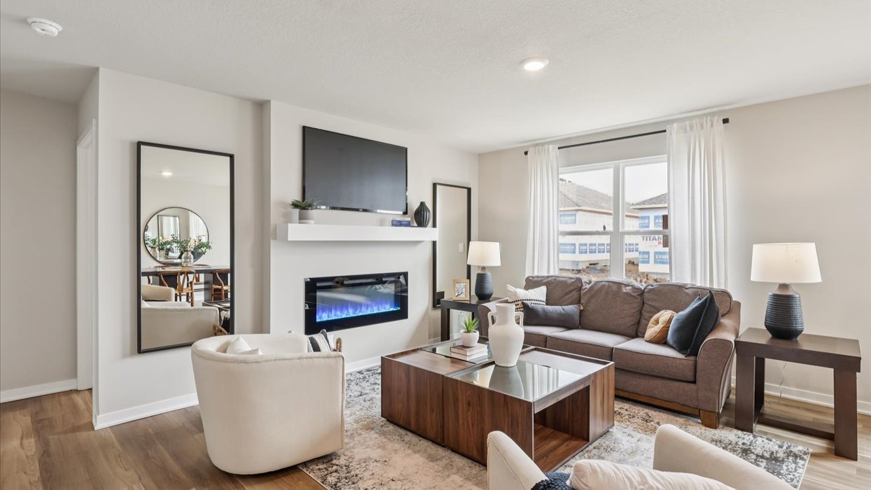 spacious living room with large window and electric fireplace