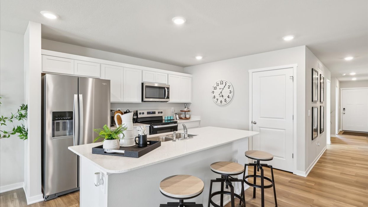 modern white kitchen with island and stainless-steel appliances