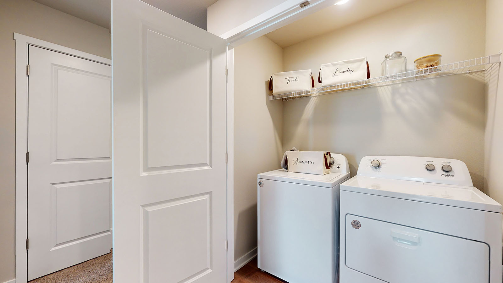 Dedicated laundry room with built-in shelving and utility connections.